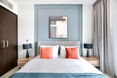 a bedroom with a large bed with orange pillows at Silkhaus near Burj Khalifa in 1BDR in 29 BLVD in Dubai