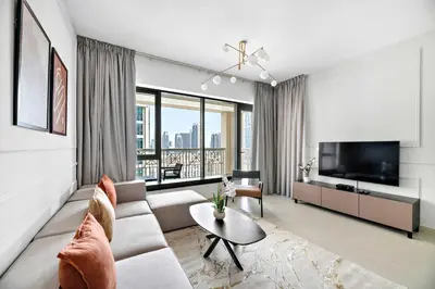 a living room with a couch and a tv at Silkhaus near Burj Khalifa in 1BDR in 29 BLVD in Dubai