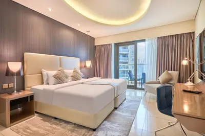 a bedroom with a bed and a desk and a couch at Spacious 2 Bedroom Apartment in DAMAC Towers by Paramount Dubai with Pool Gym Free Parking Sleeps 4 by Stayfinity in Dubai