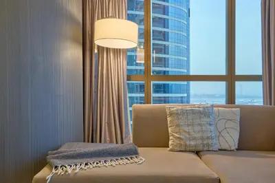 a living room with a couch and a large window at Spacious 2 Bedroom Apartment in DAMAC Towers by Paramount Dubai with Pool Gym Free Parking Sleeps 4 by Stayfinity in Dubai