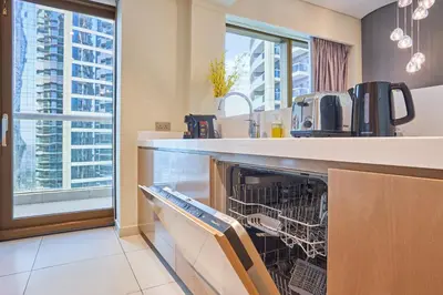 a kitchen with a dishwasher with a view of a city at Spacious 2 Bedroom Apartment in DAMAC Towers by Paramount Dubai with Pool Gym Free Parking Sleeps 4 by Stayfinity in Dubai