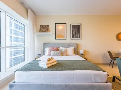 a bedroom with a large bed with two towels on it at Stylish Studio Escape in the Heart of JLT in Dubai