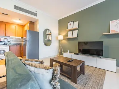 a living room with a couch and a table at Stylish Studio Escape in the Heart of JLT in Dubai