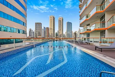a swimming pool with a city skyline in the background at Stylish Escape with Balcony, Canal and Burj Khalifa Views Near Dubai Mall in Dubai