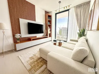 a living room with a couch and a flat screen tv at GOLDEN NUMBER by Design Studio in Dubai
