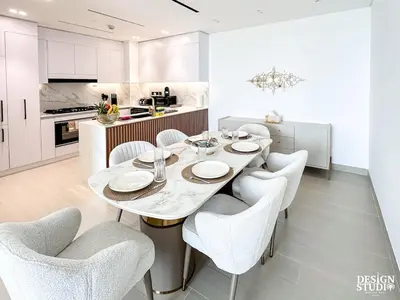 a white kitchen with a dining table and chairs at GOLDEN NUMBER by Design Studio in Dubai