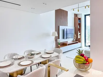 a dining room with a table with chairs and a television at GOLDEN NUMBER by Design Studio in Dubai