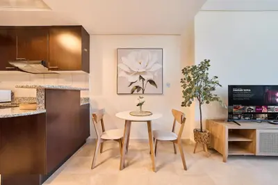 a kitchen and dining room with a table and chairs at Sleek DIFC Studio Perfect for Business & Leisure in Dubai