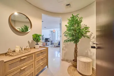 a bathroom with a dresser with a mirror and a tree at Sleek DIFC Studio Perfect for Business & Leisure in Dubai