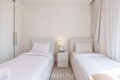 two beds in a small room with a side table at Burj Crown - Spectacular 2 BR next to Burj Khalifa - Zed Living in Dubai