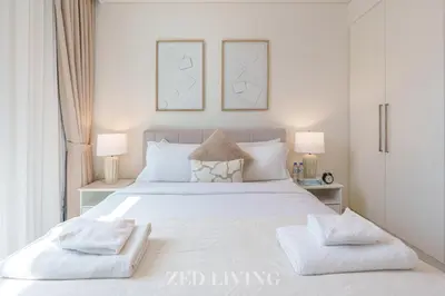 a bedroom with a large white bed with two lamps at Burj Crown - Spectacular 2 BR next to Burj Khalifa - Zed Living in Dubai