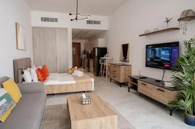 a living room with a couch and a tv at Stunning City Views and Outdoor Pool, Steps from Iconic Burj Khalifa in Dubai
