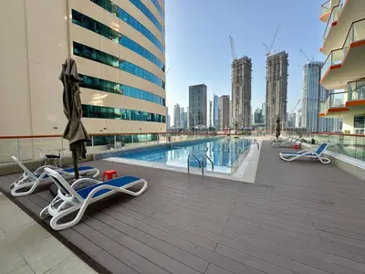 a swimming pool with chaise lounge chairs on a building at Stunning City Views and Outdoor Pool, Steps from Iconic Burj Khalifa in Dubai