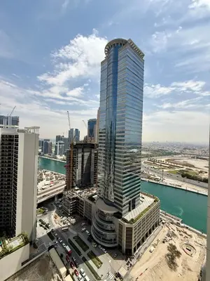 a tall building in a city with traffic in front of it at Damac MERANO LUX 2 bedroom 3 baths in Dubai