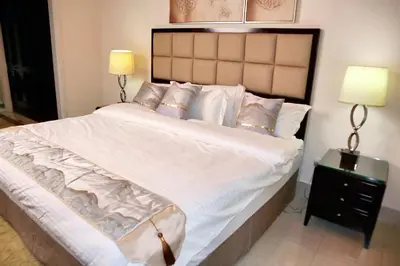 a bedroom with a large bed with white sheets and pillows at Full View Burj Khalifa and Fountains -Souk Al Bahar- Dream View holiday Home Rental in Dubai