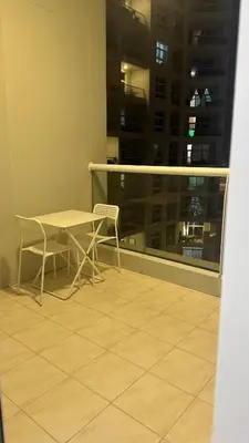 a table and chairs on a balcony with a window at Katkeys in Dubai