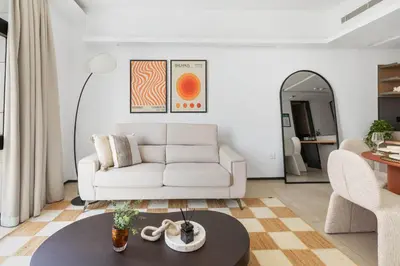 a living room with a white couch and a table at New 1BR with Walk-in Wardrobe in Greenish Community in Dubai