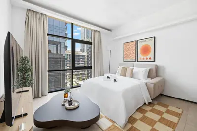 a bedroom with a white bed and a large window at New 1BR with Walk-in Wardrobe in Greenish Community in Dubai