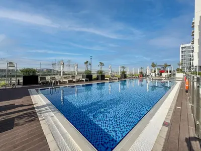 a large swimming pool on the roof of a building at Bright and Sleek Azizi Studio Prime Meydan Location in Dubai