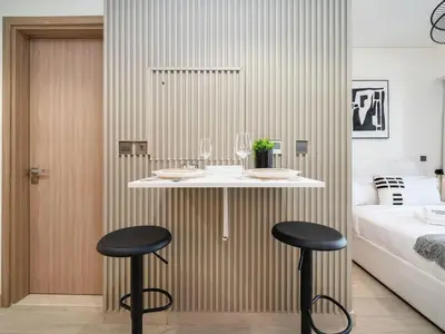 a hotel room with two bar stools and a bed at Bright and Sleek Azizi Studio Prime Meydan Location in Dubai
