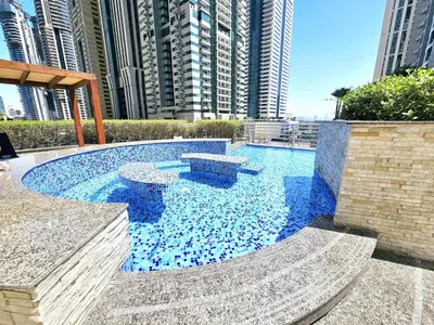 a swimming pool with blue water and some buildings at SUNRISE HOMES - Spacious 1BR next to Marina Walk in Dubai