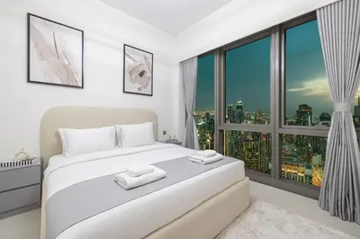 a bedroom with a white bed and a large window at Great View from 63th Floor! Amazing Pool with Burj View! Grande Signature! in Dubai