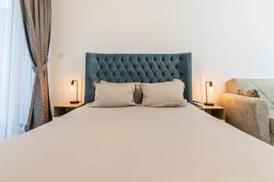 a bedroom with a large bed with a blue headboard at Bright Studio Crystal Residence JVC in Dubai