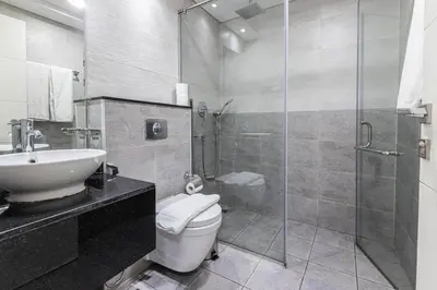 a bathroom with a shower and a toilet and a sink at Bright Studio Crystal Residence JVC in Dubai