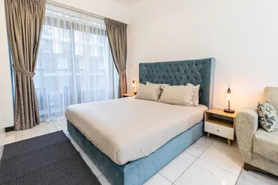 a bedroom with a bed and a couch and a window at Bright Studio Crystal Residence JVC in Dubai