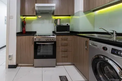 a kitchen with a stove and a washing machine at Bright Studio Crystal Residence JVC in Dubai