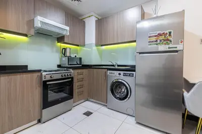 a kitchen with a stainless steel refrigerator and a dishwasher at Bright Studio Crystal Residence JVC in Dubai