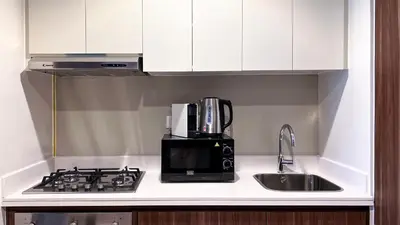 a kitchen with a microwave and a stove and a sink at KeyRock Living - Chic Reva 1BR with Pool Access in Dubai