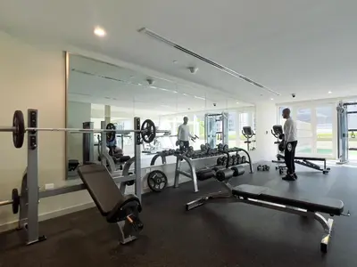 a room with two men in a gym with mirrors at KeyRock Living - Chic Reva 1BR with Pool Access in Dubai