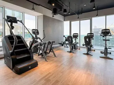 a gym with treadmills and ellipticals in a room with windows at Vogue Al Wasl 1 Residences Near Zabeel Park and World Trade Centre, Two Bedroom Apartment with Balcony and Dubai Frame, Access to all Amenities, Walkable to Max Fashion Metro Station in Dubai