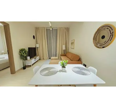 a living room with a white table and a couch at Spacious 1BR Apartment in Binghatti Emerald JVC in Dubai
