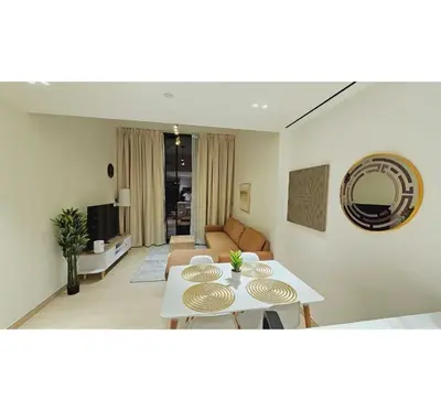 a living room with a table and a couch at Spacious 1BR Apartment in Binghatti Emerald JVC in Dubai