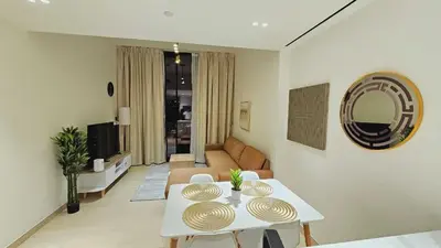 a living room with a table and a couch at Spacious 1BR Apartment in Binghatti Emerald JVC in Dubai