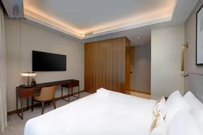 a hotel room with a bed and a desk and a television at Luxury 1-BR at Dubai Opera Stay in Dubai