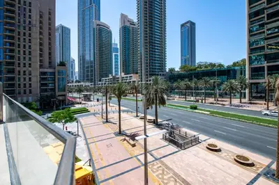 a city street with palm trees and tall buildings at Luxury 1-BR at Dubai Opera Stay in Dubai
