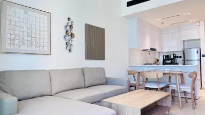 a living room with a couch and a table at Premium 1 Bed Apartment In Binghatti Venus in Dubai