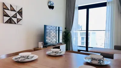 a dining room table with two cups and plates on it at Premium 1 Bed Apartment In Binghatti Venus in Dubai