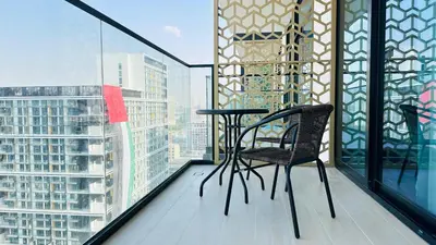 a balcony with a table and chairs on a building at OYO HOME 1457 Premium 1bed Apartment In Jvc Bh in Dubai