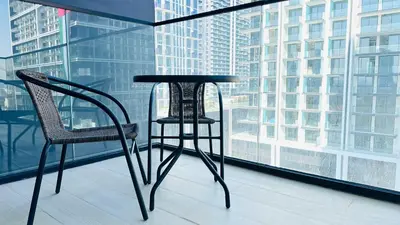 a table and two chairs in front of a window at OYO HOME 1457 Premium 1bed Apartment In Jvc Bh in Dubai