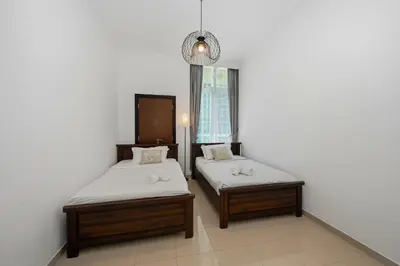 a room with two beds and a chandelier at Serene Escape in Bustling Marina and JBR, Ensuite 2BR, Sky Garden Access in Dubai