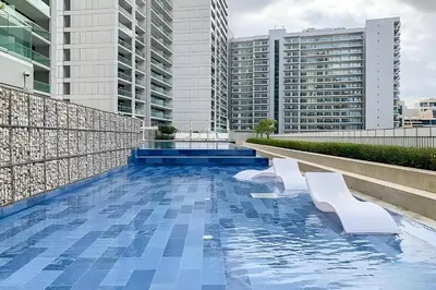a swimming pool on the roof of a building with buildings at Reva Residence - Luxe 1BR with Burj Khalifa View in Dubai