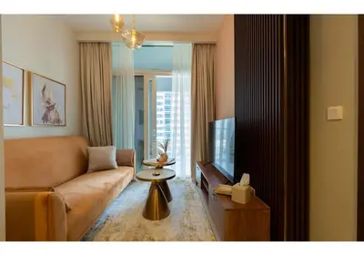 a living room with a couch and a television at Reva Residence - Luxe 1BR with Burj Khalifa View in Dubai