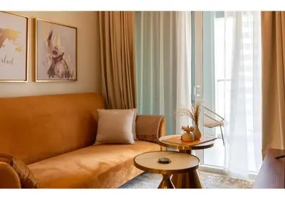 a living room with a couch and a window at Reva Residence - Luxe 1BR with Burj Khalifa View in Dubai