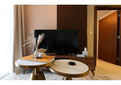a living room with two stools and a tv at Reva Residence - Luxe 1BR with Burj Khalifa View in Dubai
