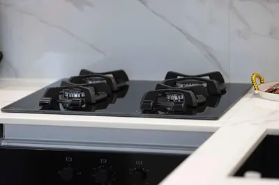a stove top with black burners on a counter at Cozy 1 BR with gym & pool just 15min to Dubai Marina in Dubai