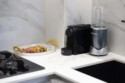 a kitchen counter with a blender on a counter top at Cozy 1 BR with gym & pool just 15min to Dubai Marina in Dubai